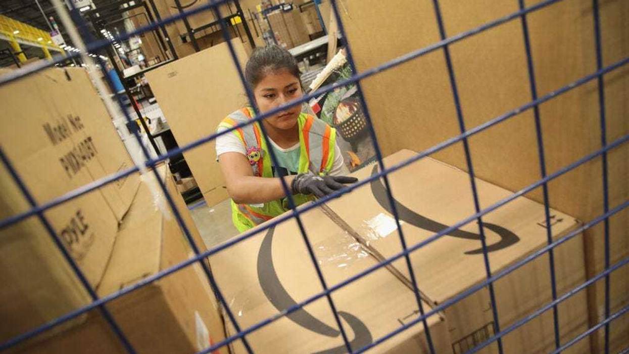 Workers pack and ship customer orders at an Amazon fulfillment center.