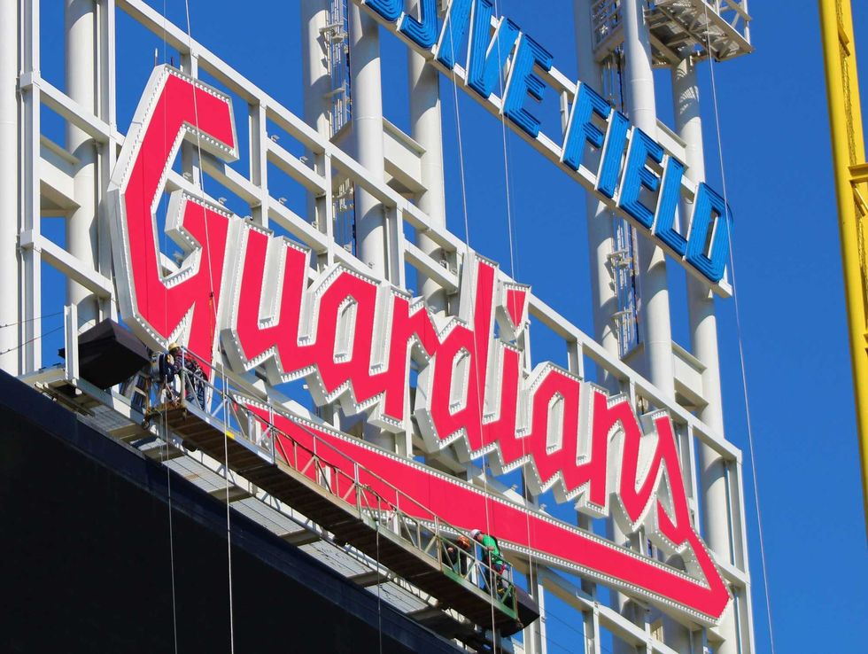 Workers put the finishing touches on the new guardians sign atop the scoreboard at Progressive Field.
