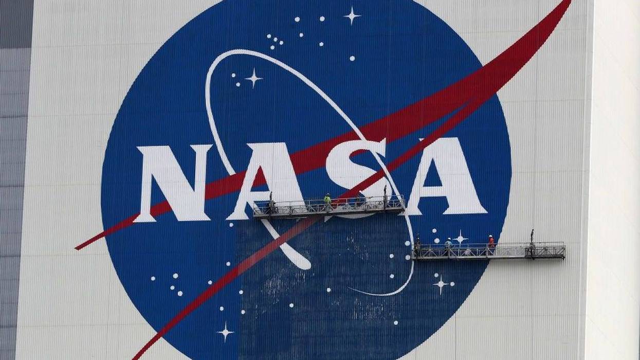 Workers repaint the NASA logo on the Vehicle Assembly Building at the Kennedy Space Center on May 28, 2020 in Cape Canaveral, Florida