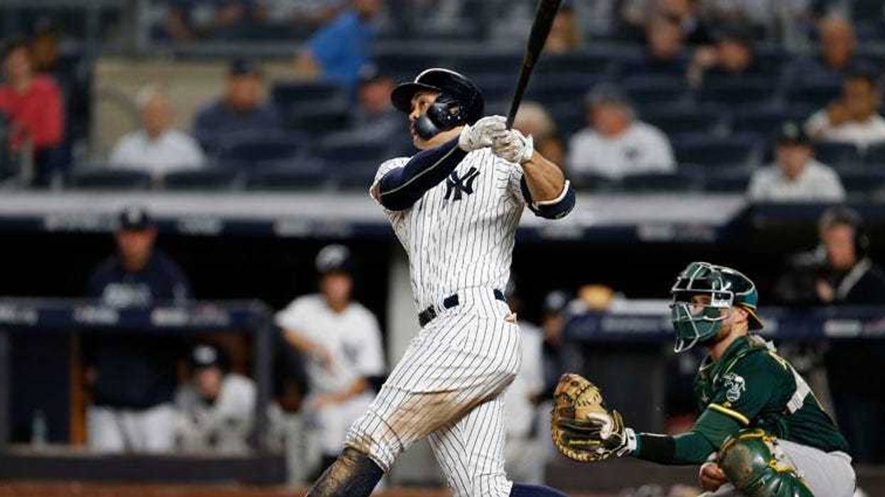 Yankees left fielder Giancarlo Stanton hits a solo home run during the eighth inning against the Oakland Athletics on Oct. 3, 2018, in a wild-card playoff game at Yankee Stadium.