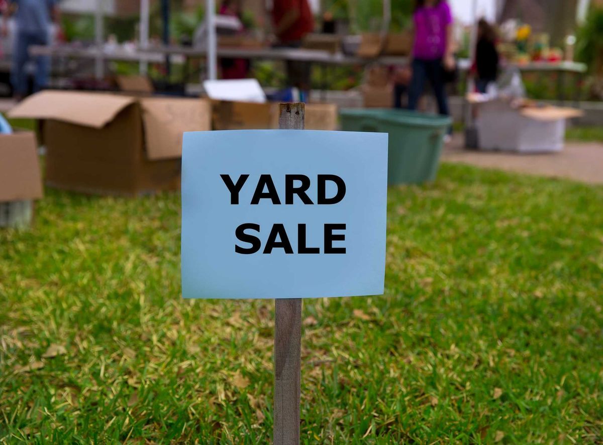 Yard sale sign in front of a yard sale.