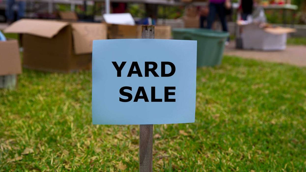 Yard sale sign in front of a yard sale.
