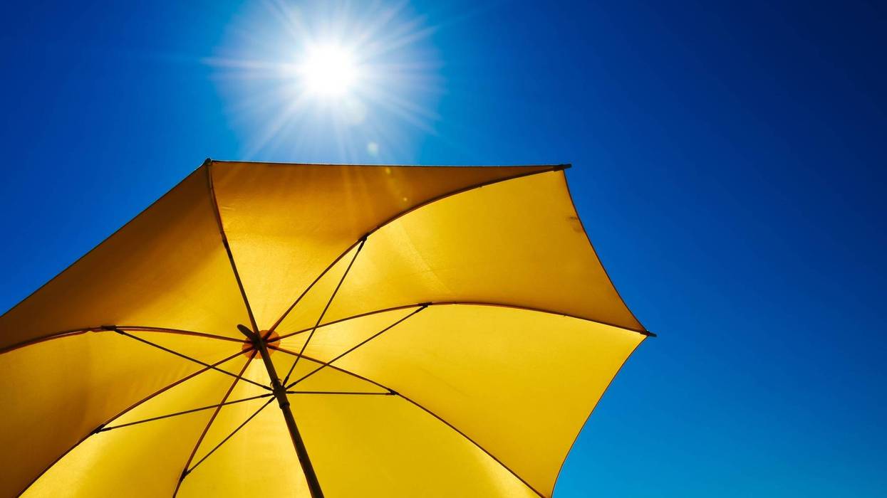 Yellow Umbrella With Bright Sun And Blue Sky