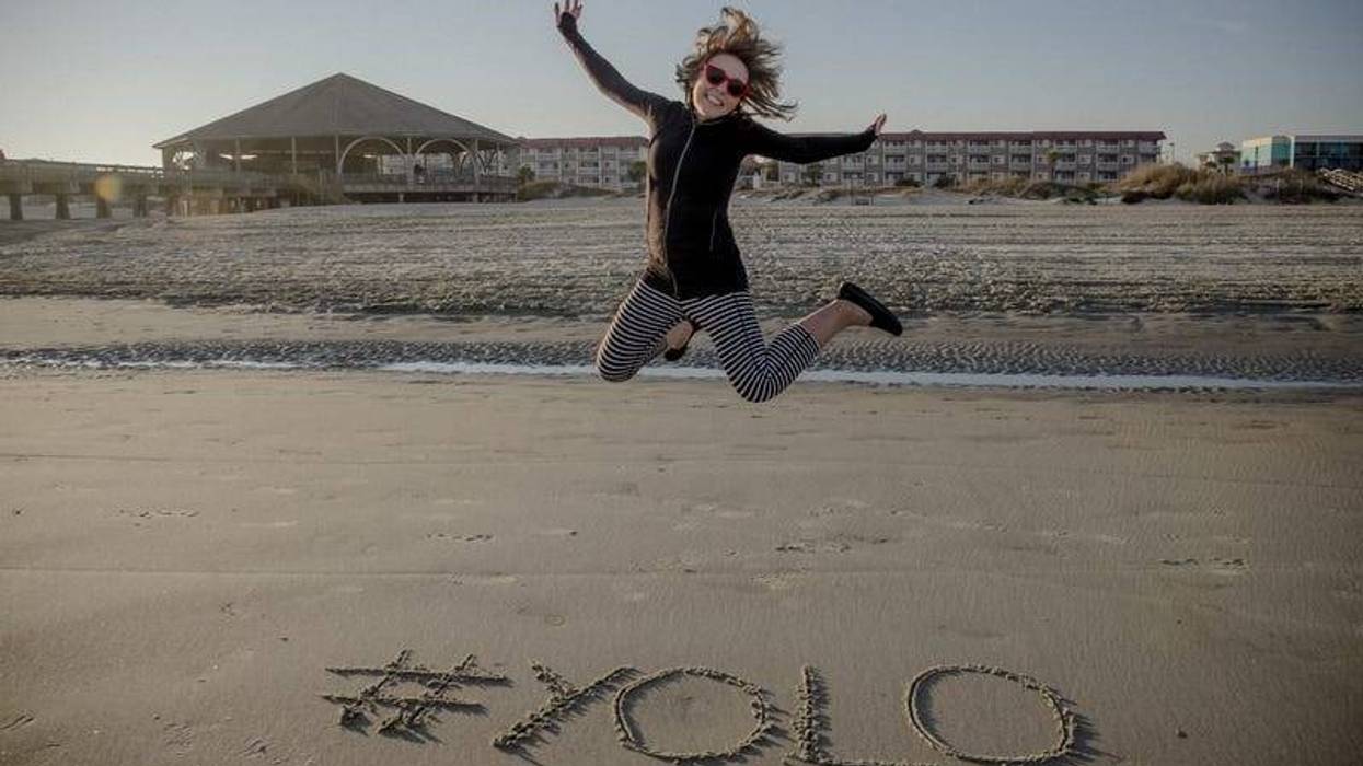 YOLO girl jumping on beach
