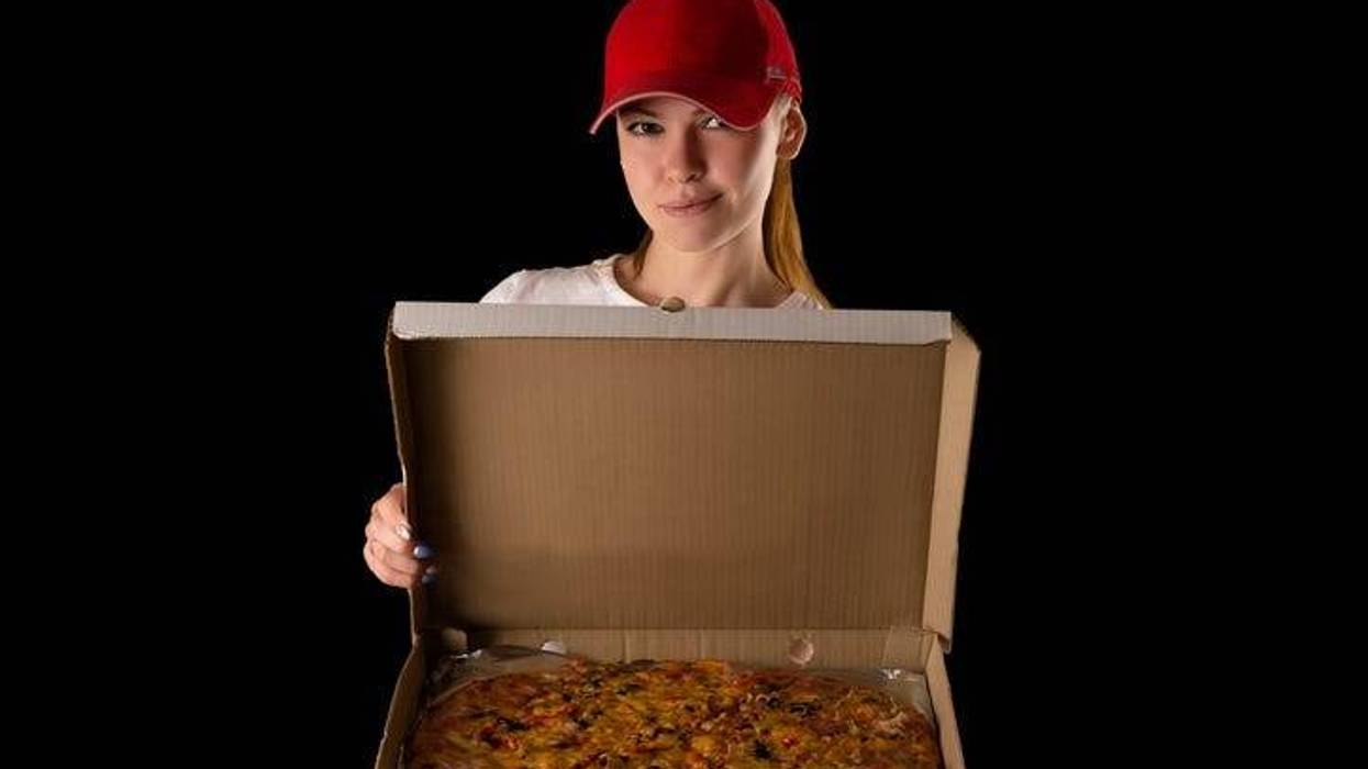 young attractive girl with a pizza box isolated on black background