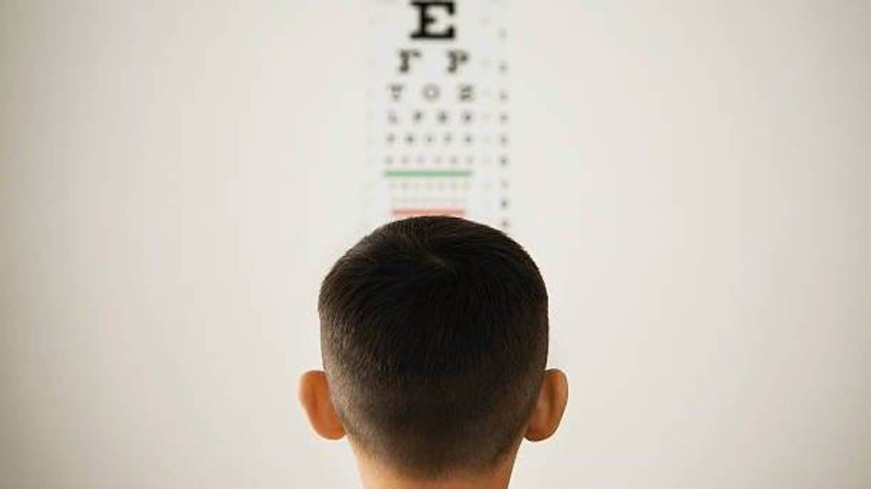 young boy looking at wall eye chart