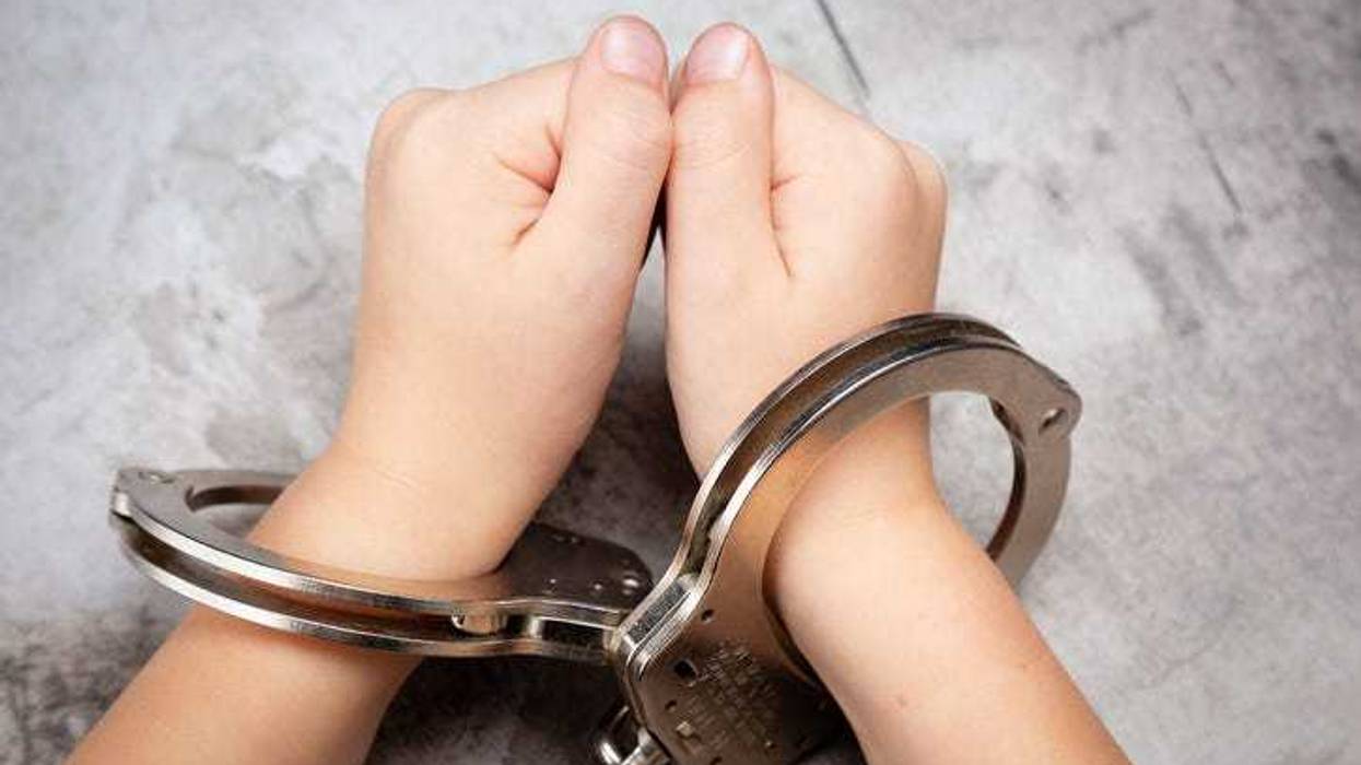 Young Child's Hands in Jail Handcuffs