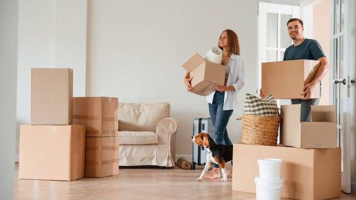 Young couple with a dog moving into a new home
