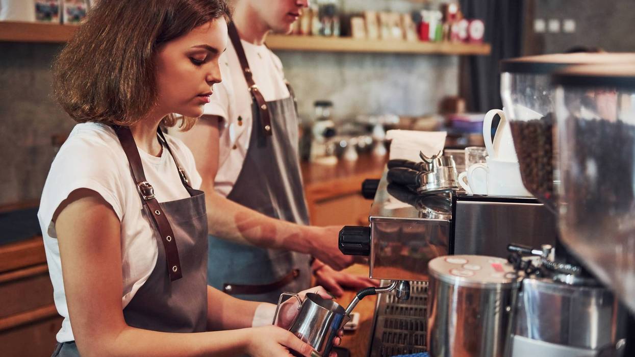 Young female cafe worker indoors. Conception of business and service