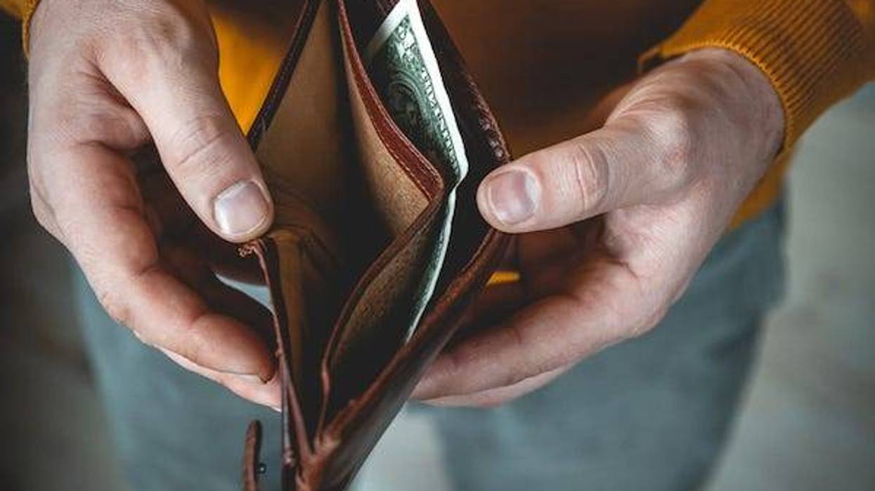 Young man holding empty wallet