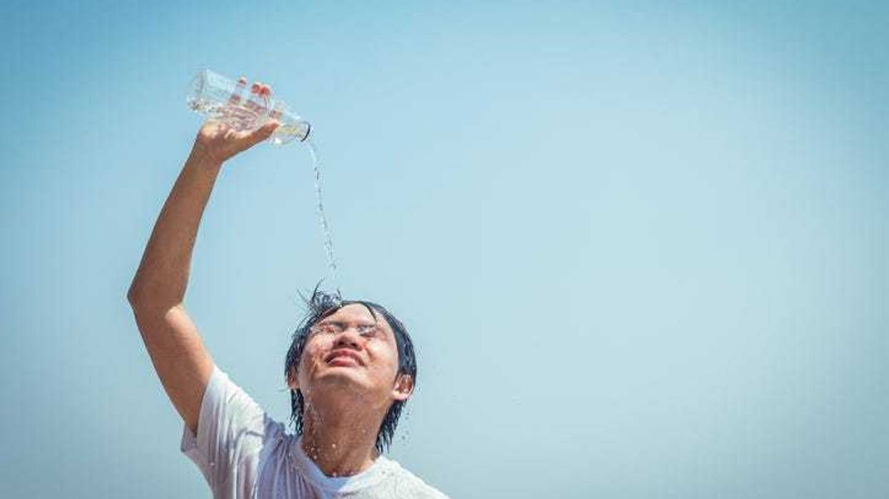 young man pouring cold water on head