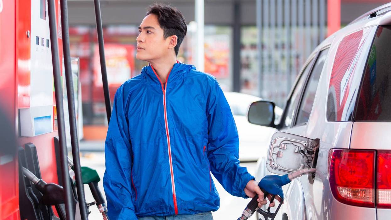 young man refuelling in self service gas station. refuel in tank automobile. transportation concept.