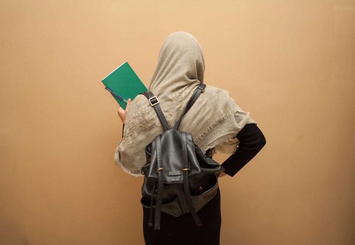 young student in a hijab with school books