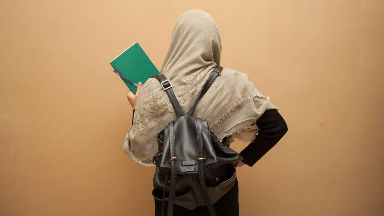young student in a hijab with school books