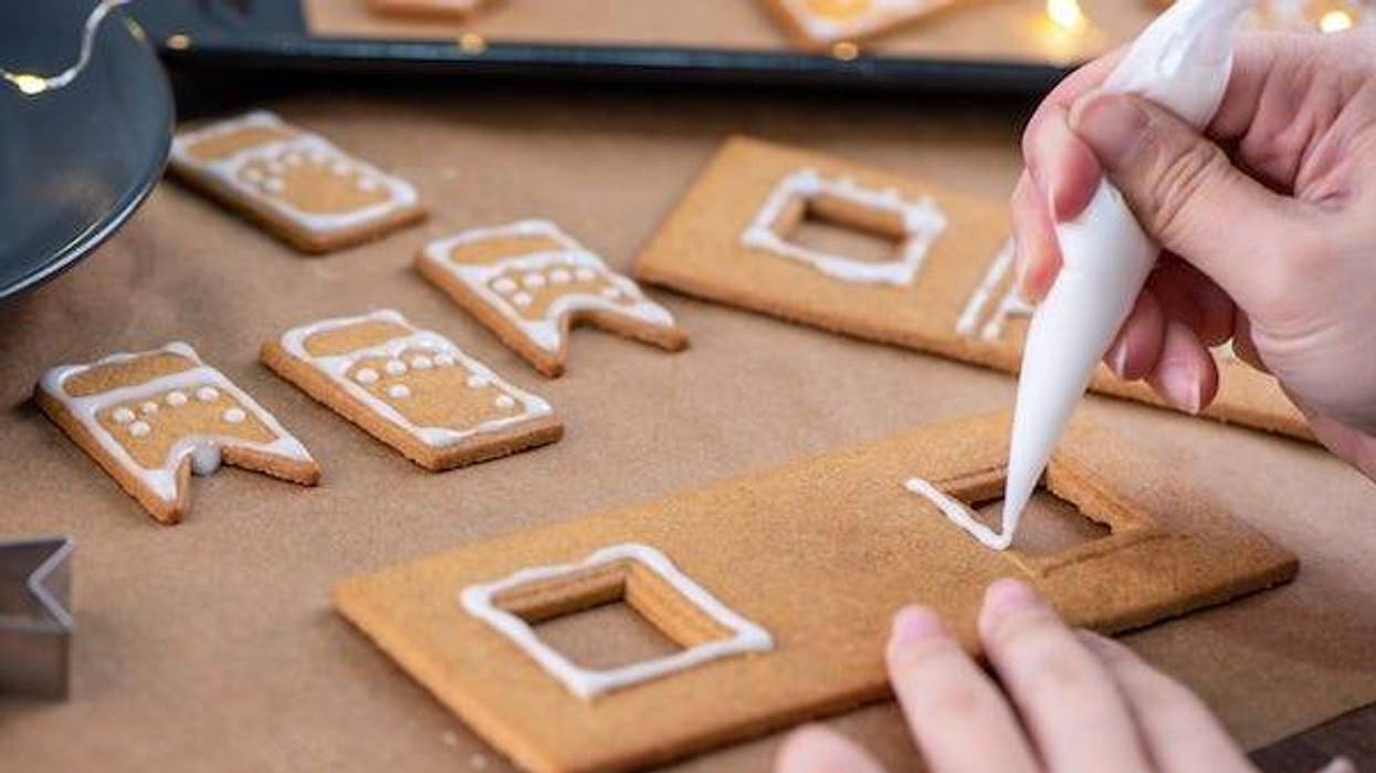 Young woman decorating Gingerbread House
