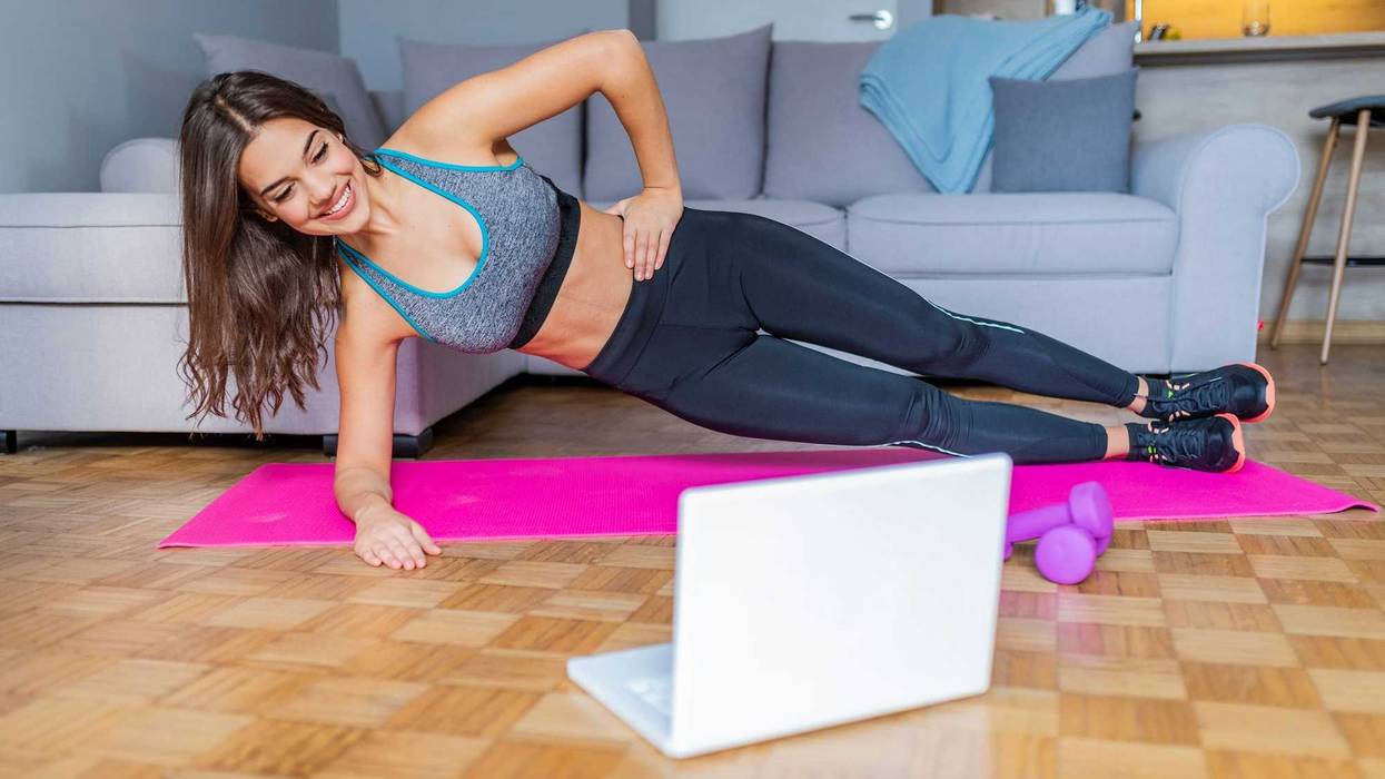 Young woman exercising at home in a living room