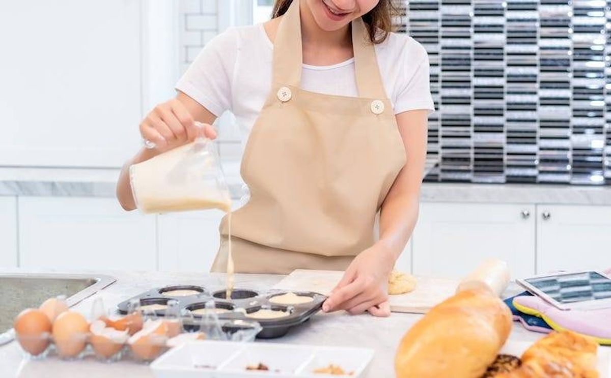 Young woman pouring batter