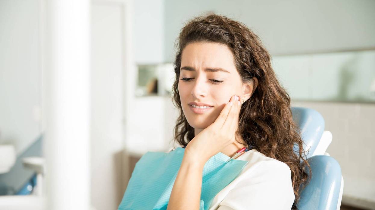 Young Woman Suffering From Toothache In Dental Clinic