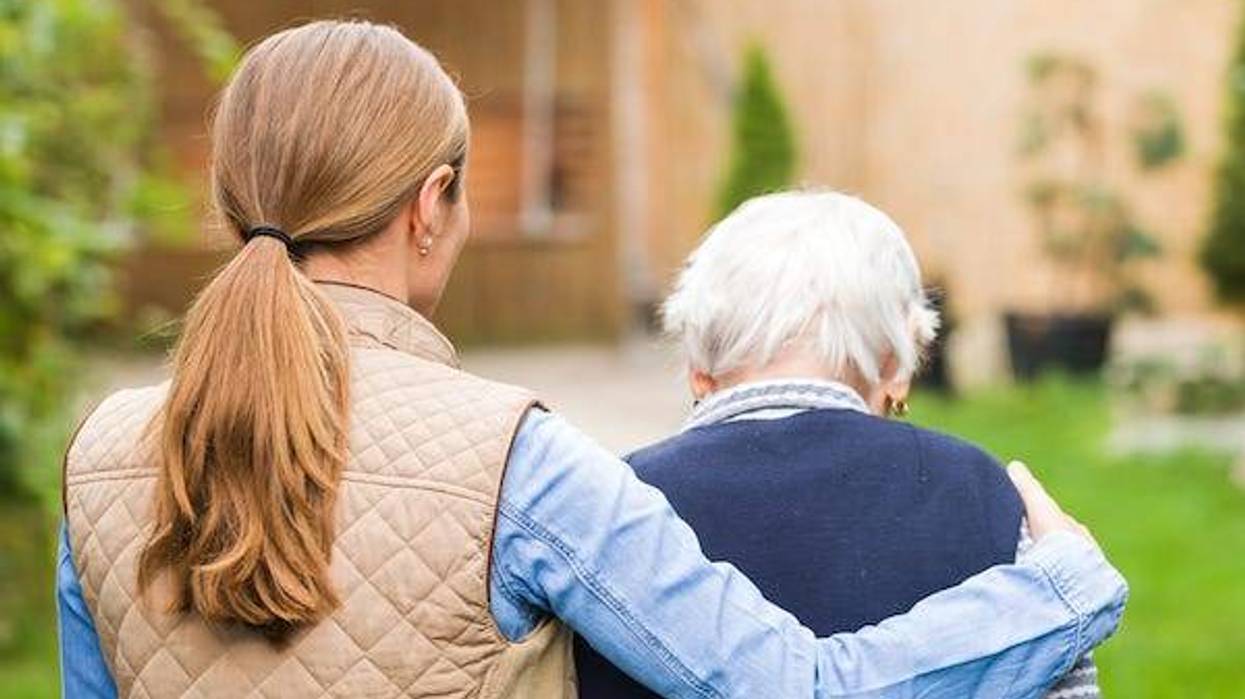 Young woman walking with older woman outdoors