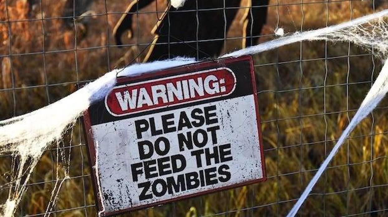 Zombie warning sign with zombies in the background